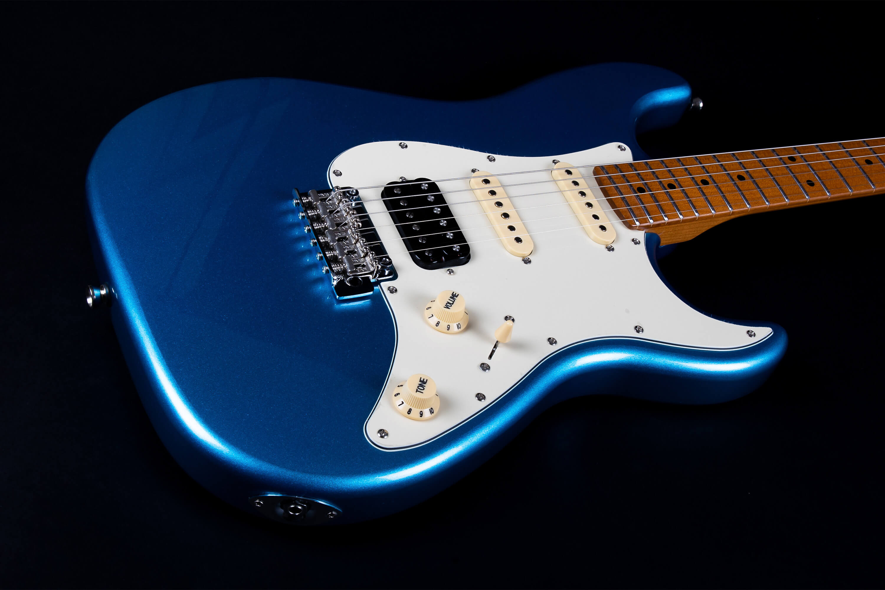 Electric guitar with a metallic blue body, white pickguard, three pickups, and light wood fretboard, shown against a black background.