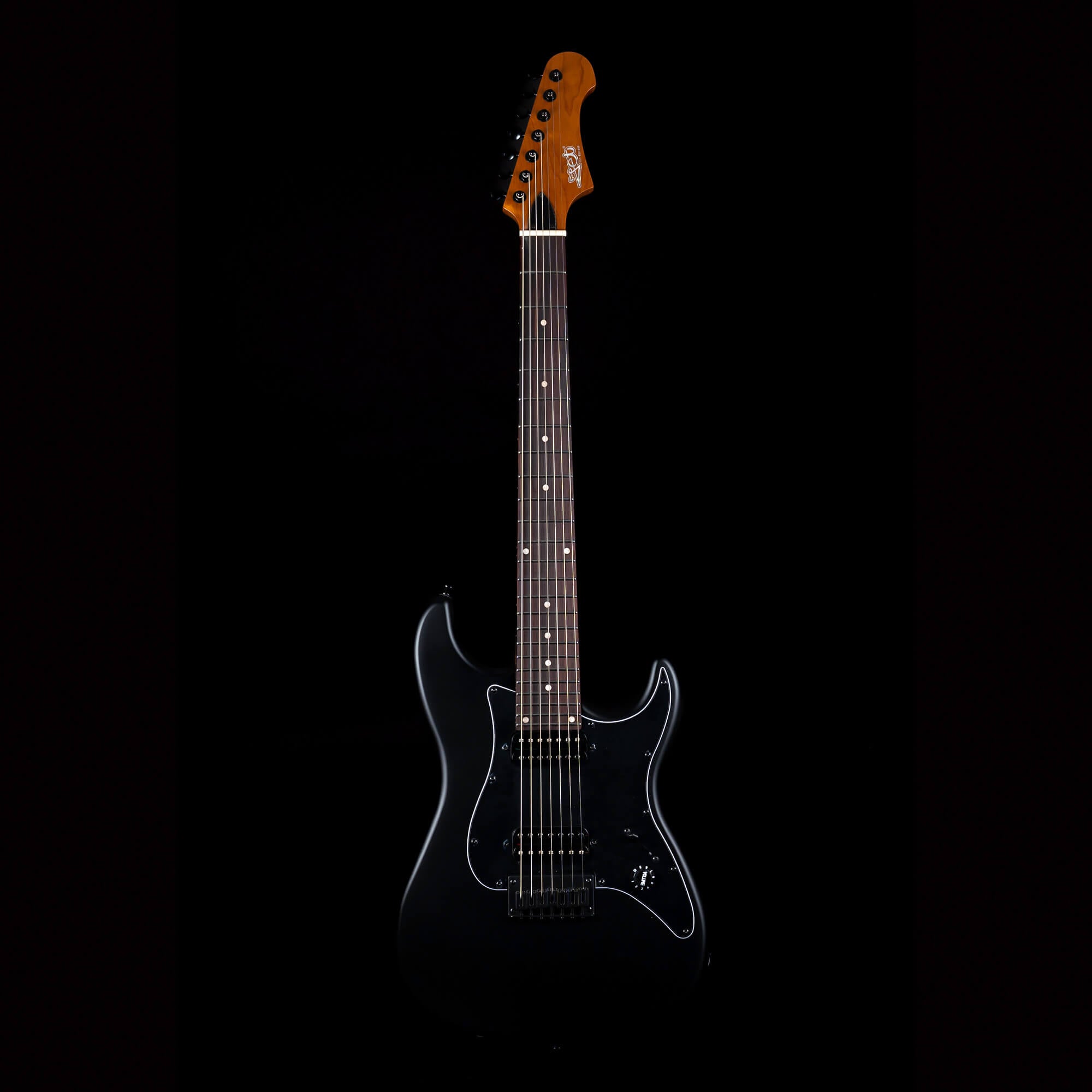 Black electric guitar with a glossy finish, dark pickguard, six strings, and a brown wooden headstock with black tuning pegs.
