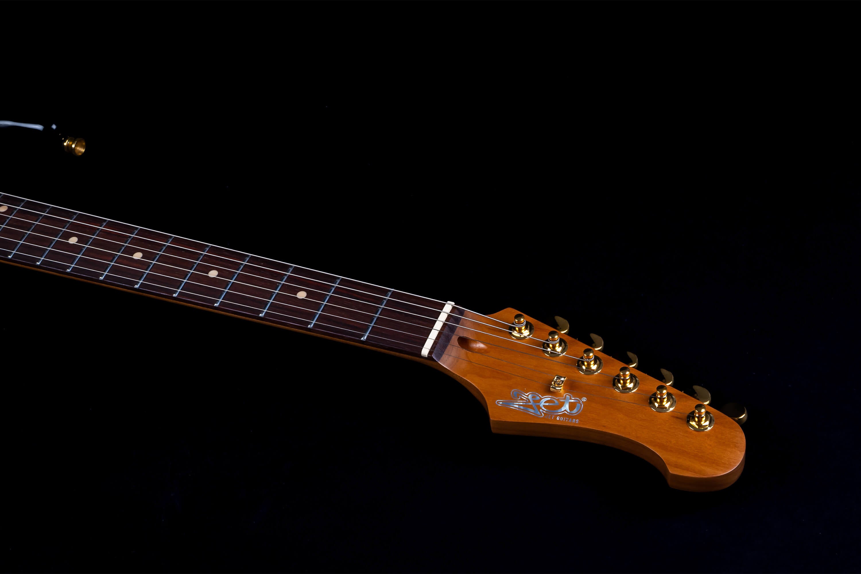 Jet Guitars electric guitar neck with a rosewood fretboard, pearl inlays, and six gold tuning pegs on a headstock with Jet Guitars logo.