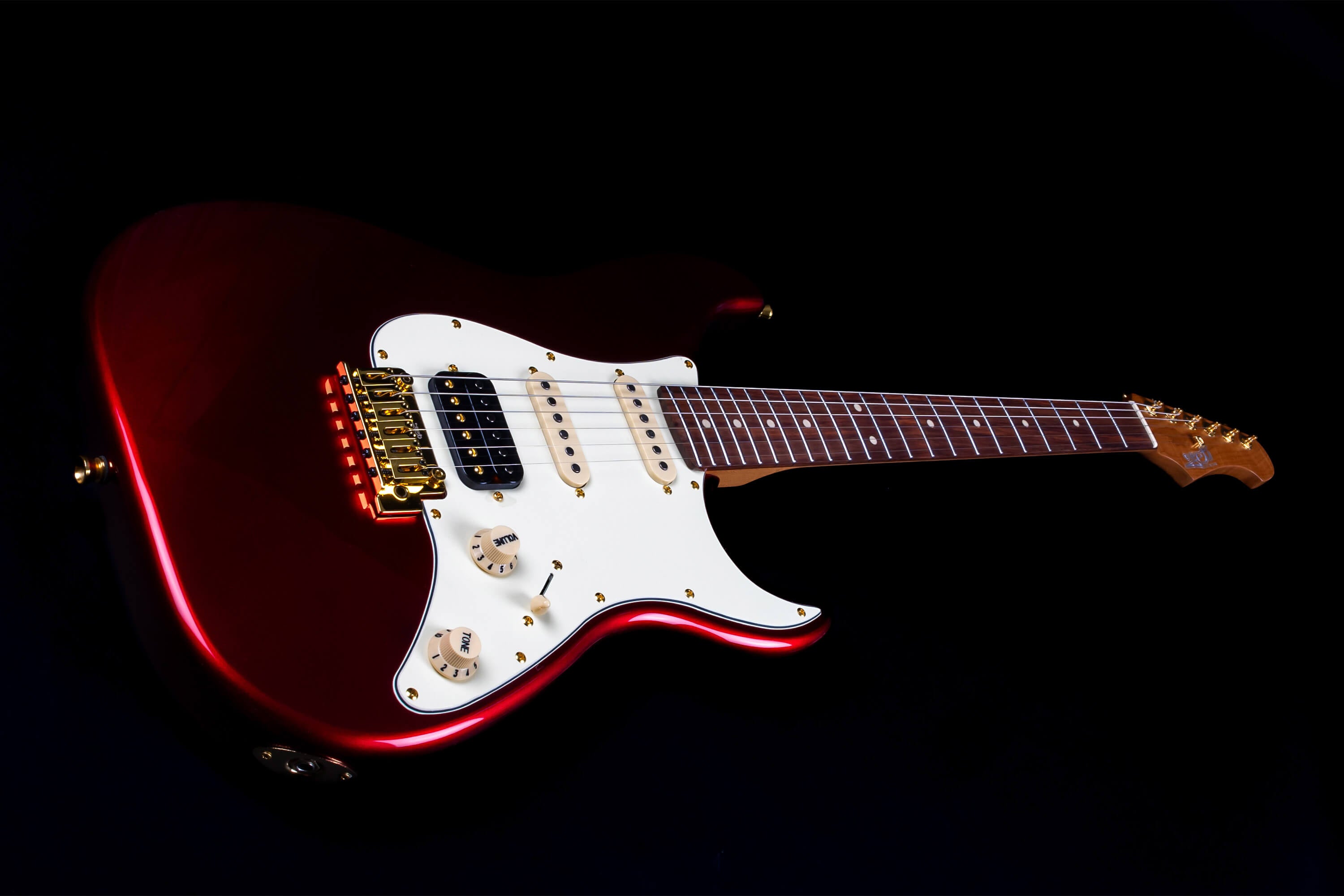Electric guitar with a glossy dark red body, white pickguard, gold hardware, three pickups, and a brown fingerboard, shown on a black background.