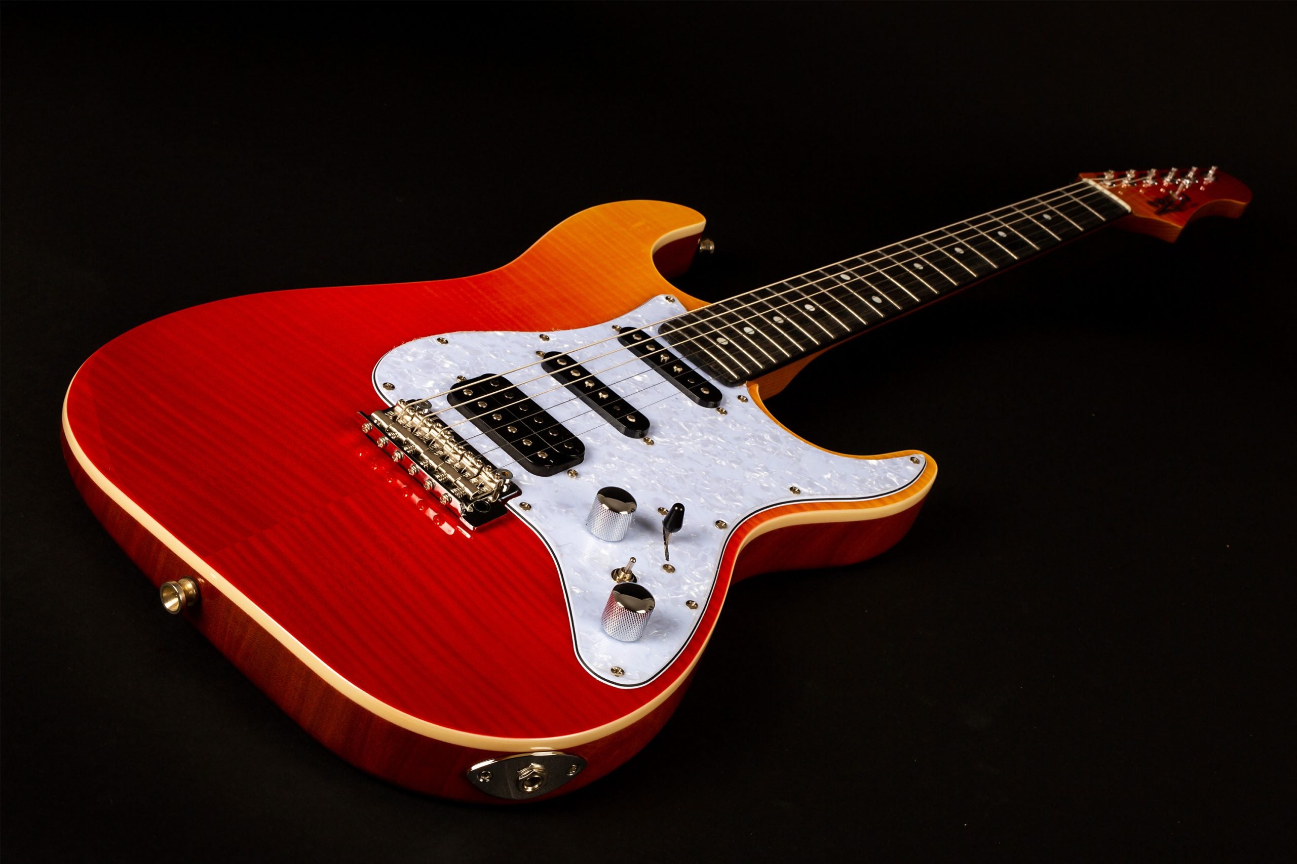 Electric guitar with a glossy red-to-orange sunburst body, white pearloid pickguard, three pickups, two control knobs, and a dark fretboard.