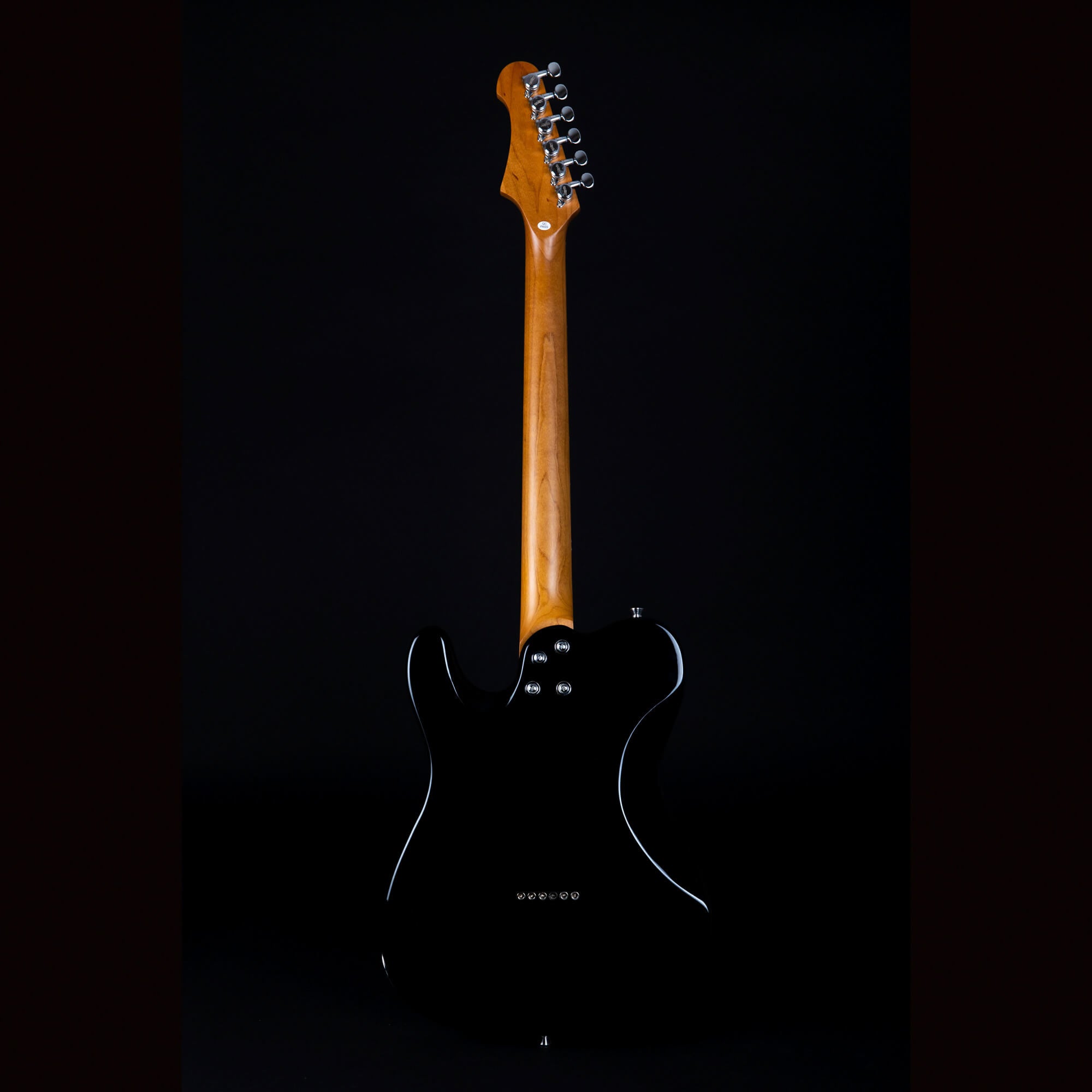 Electric guitar shown from the back, with a glossy black body and a natural wood neck, tuning pegs visible on the headstock.