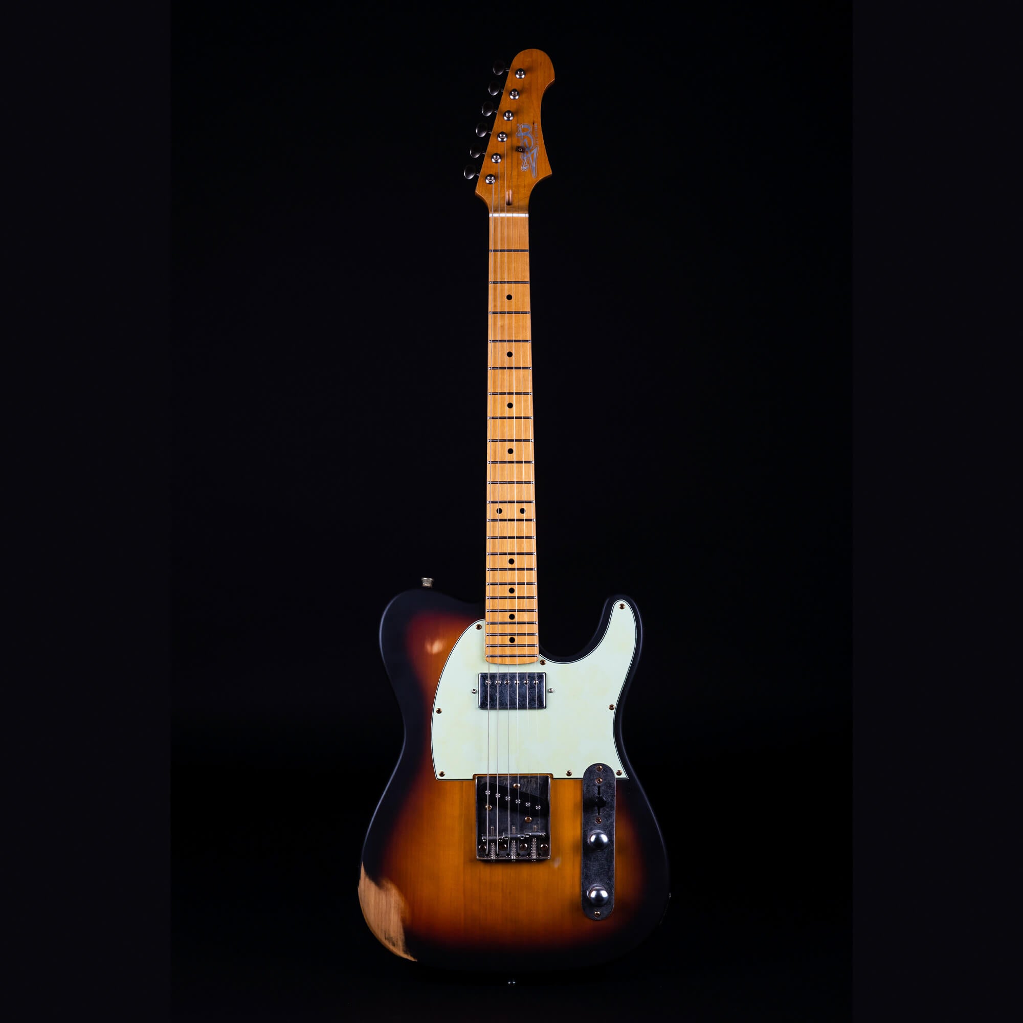 Sunburst electric guitar with a white pickguard, maple neck, and visible wood wear on the lower body edge.