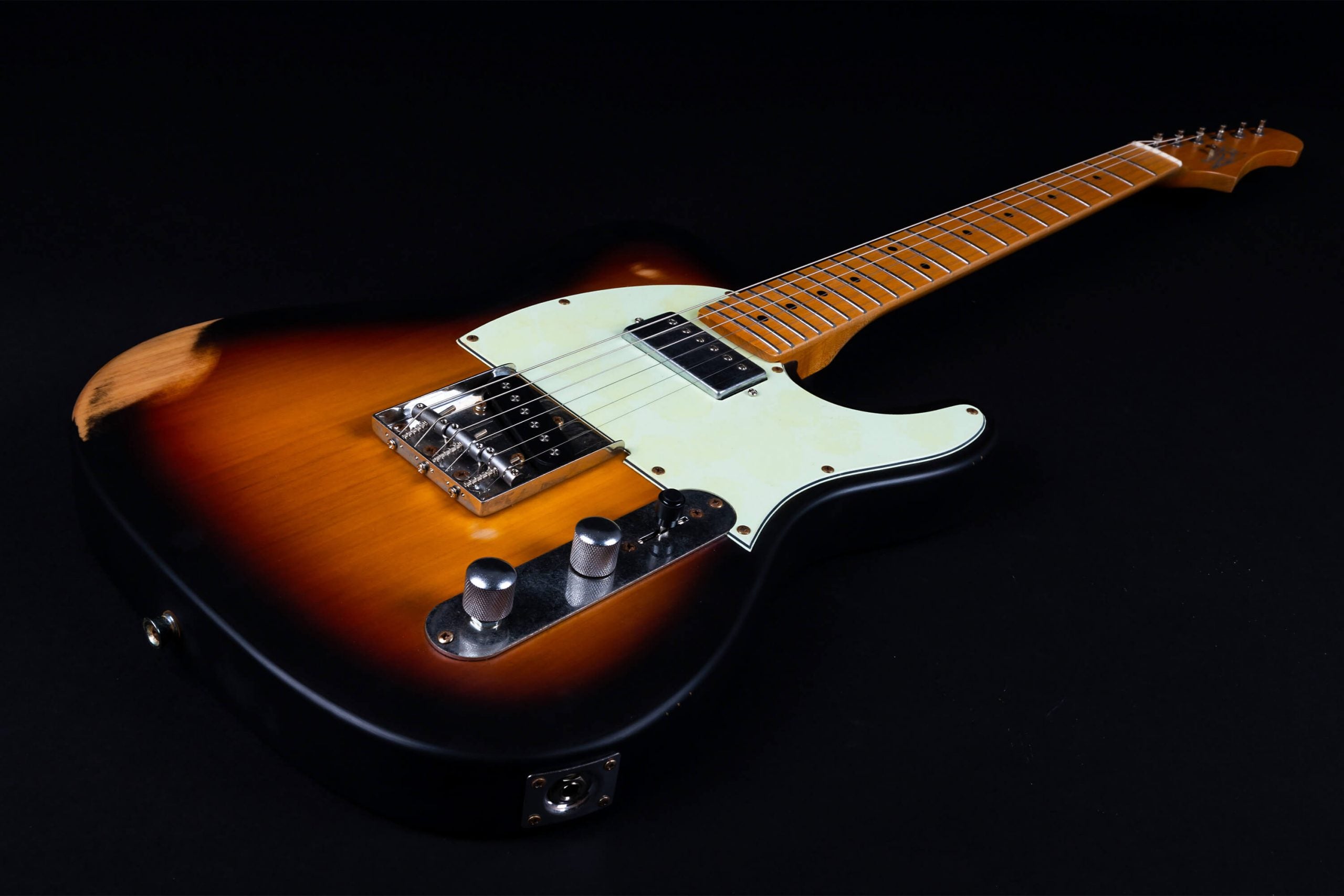Sunburst electric guitar with single-cutaway body, maple neck, metal bridge, and two chrome control knobs. One worn spot on the upper edge.