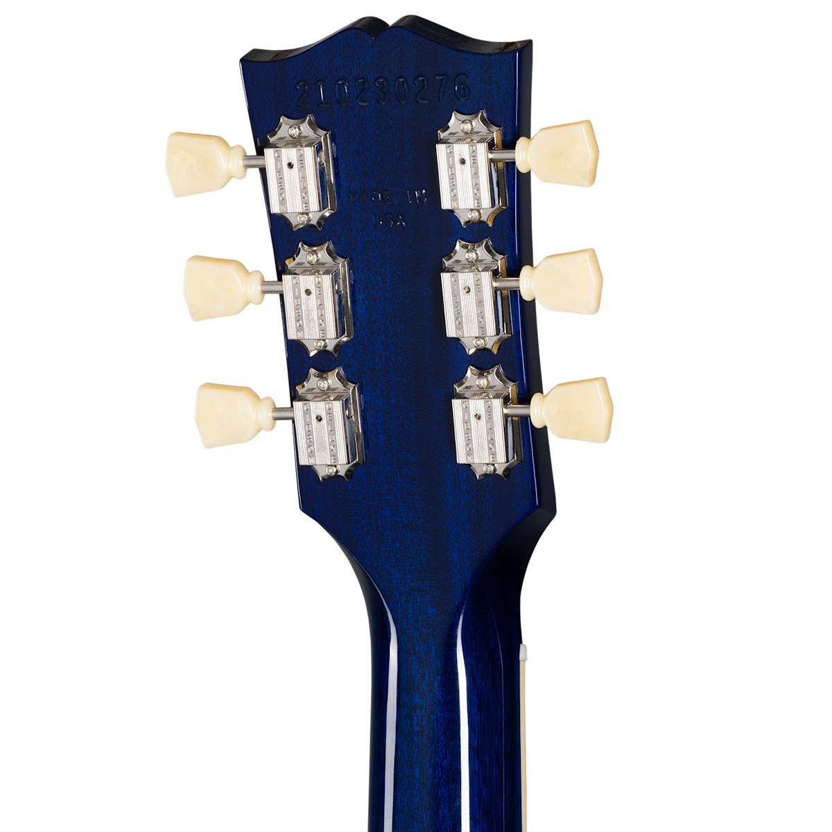 Back of a blue electric guitar headstock showing six vintage-style tuning pegs with cream knobs and stamped serial numbers above.