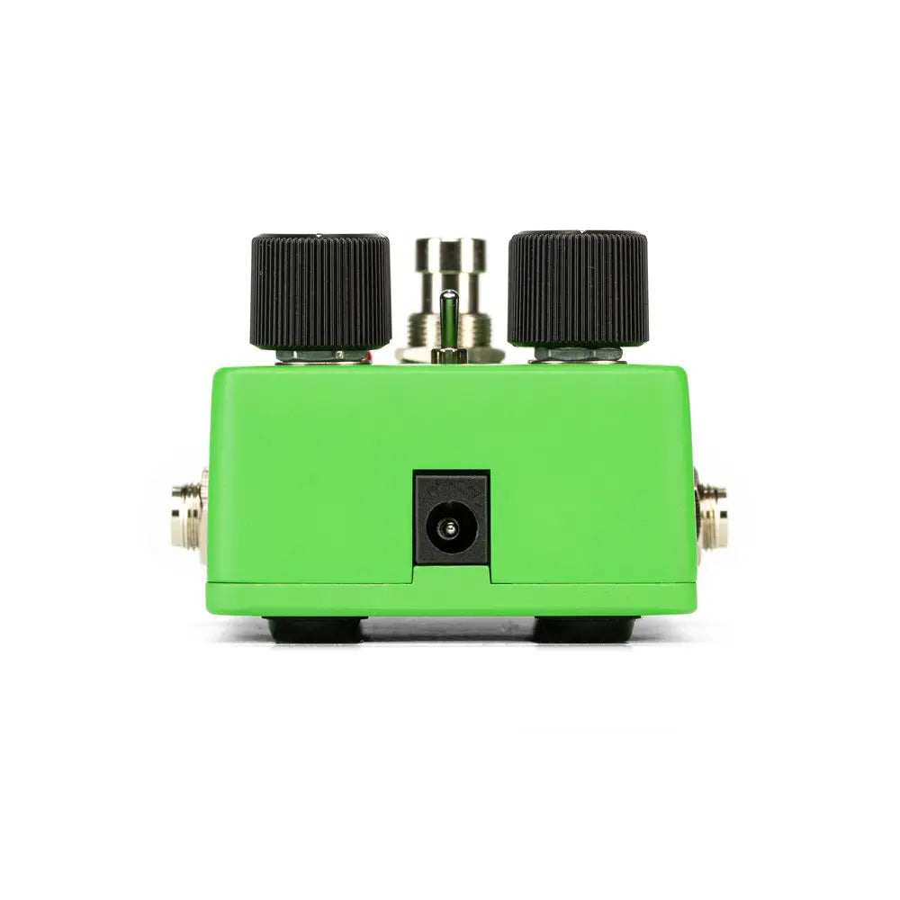 Bright green effects pedal with two large black knobs, a central footswitch, a power input, and jacks on each side.