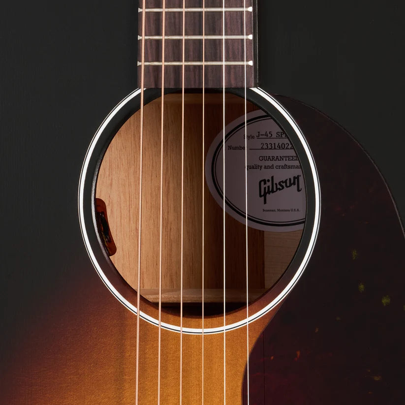 Close-up of an Epiphone acoustic guitar sound hole with six strings, sunburst finish, and a visible interior label through the round opening.