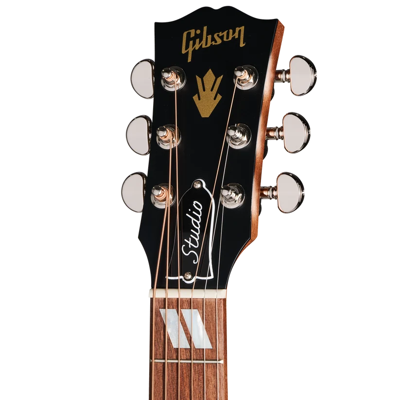 Tête de guitare Gibson noire avec six mécaniques argentées, logo doré, plaque "Studio" et touches en bois avec marques blanches.