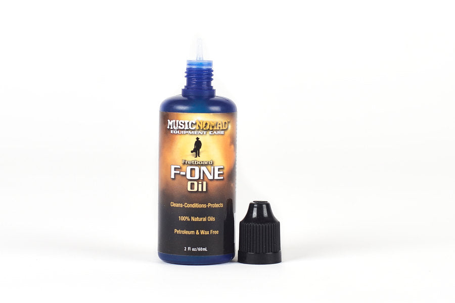 Blue bottle of MusicNomad F-ONE Oil for fretboards, 2 oz, with black twist cap removed and placed beside the bottle.