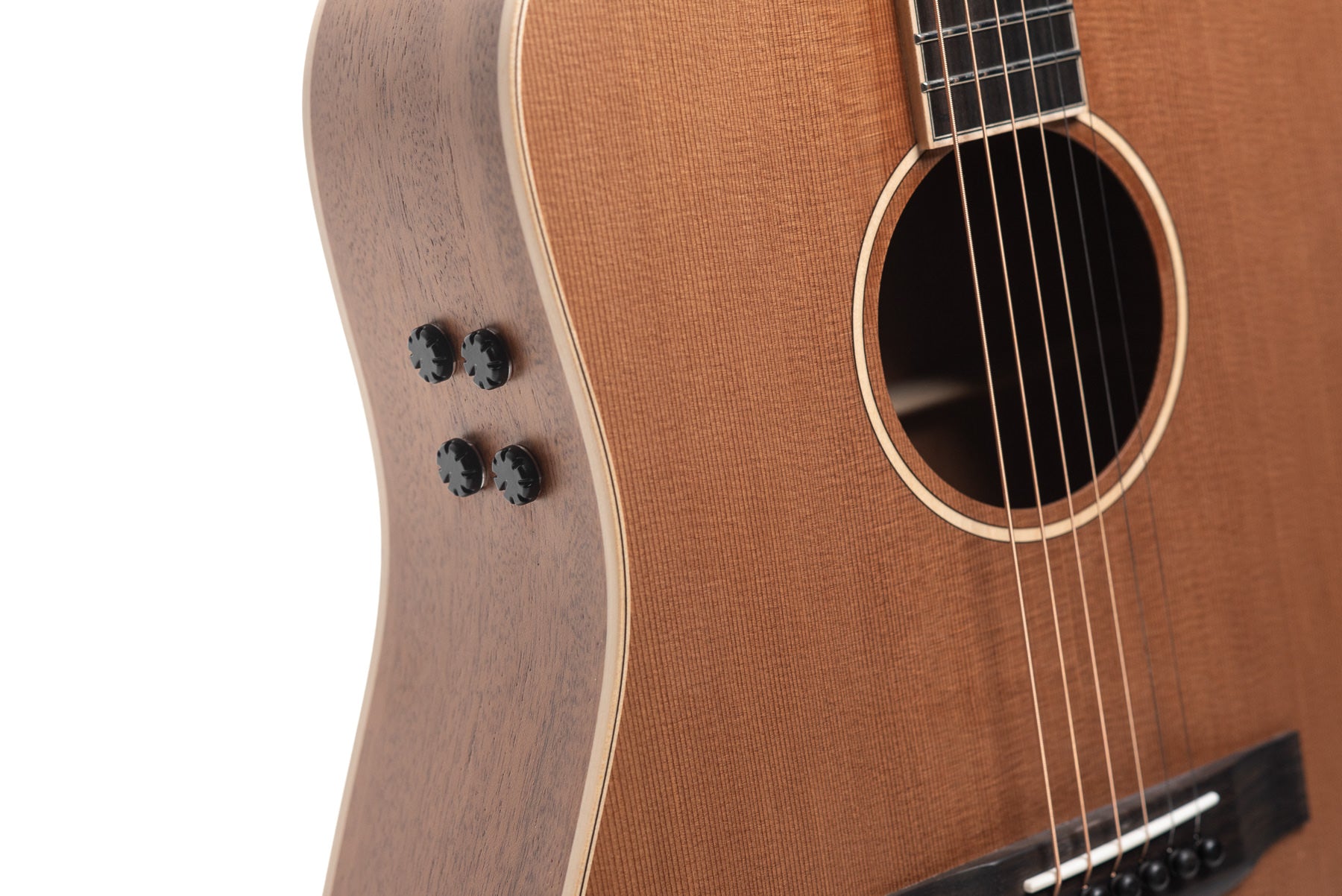Light brown acoustic guitar with four black control knobs on the side and steel strings over a dark soundhole and bridge.