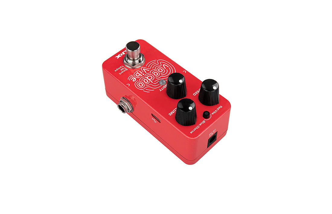 Bright red FX pedal with three black knobs, a footswitch, input and output jacks, and white “Voodoo Vibe” text in a playful font on top.
