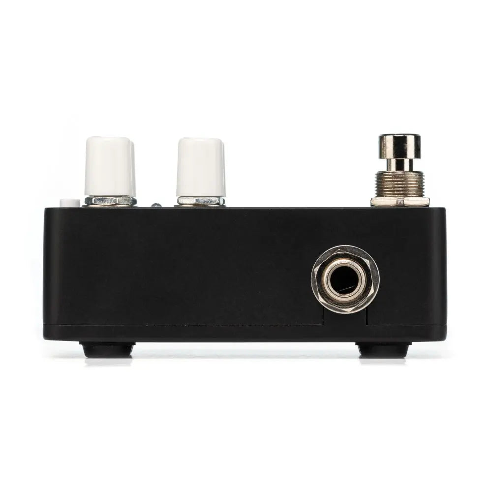 Black FX pedal with two white knobs, one large metal footswitch, and a single quarter-inch input jack on the front panel.