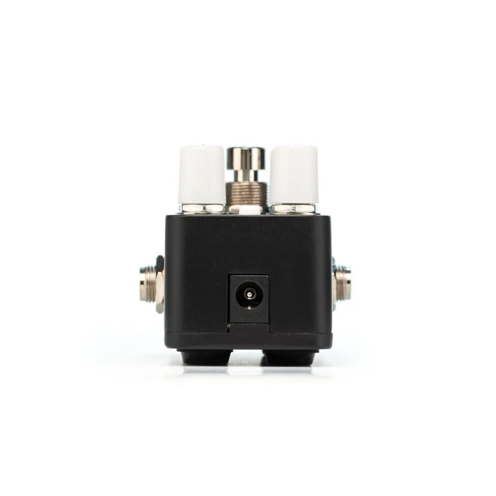 Compact FX pedal, black with two white control knobs on top, a central footswitch, and a power input jack on the front panel.