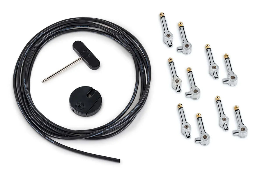 Guitar pedalboard cable kit including a long black cable, ten right-angle plugs, a round cable cutter, and a T-handle screwdriver.