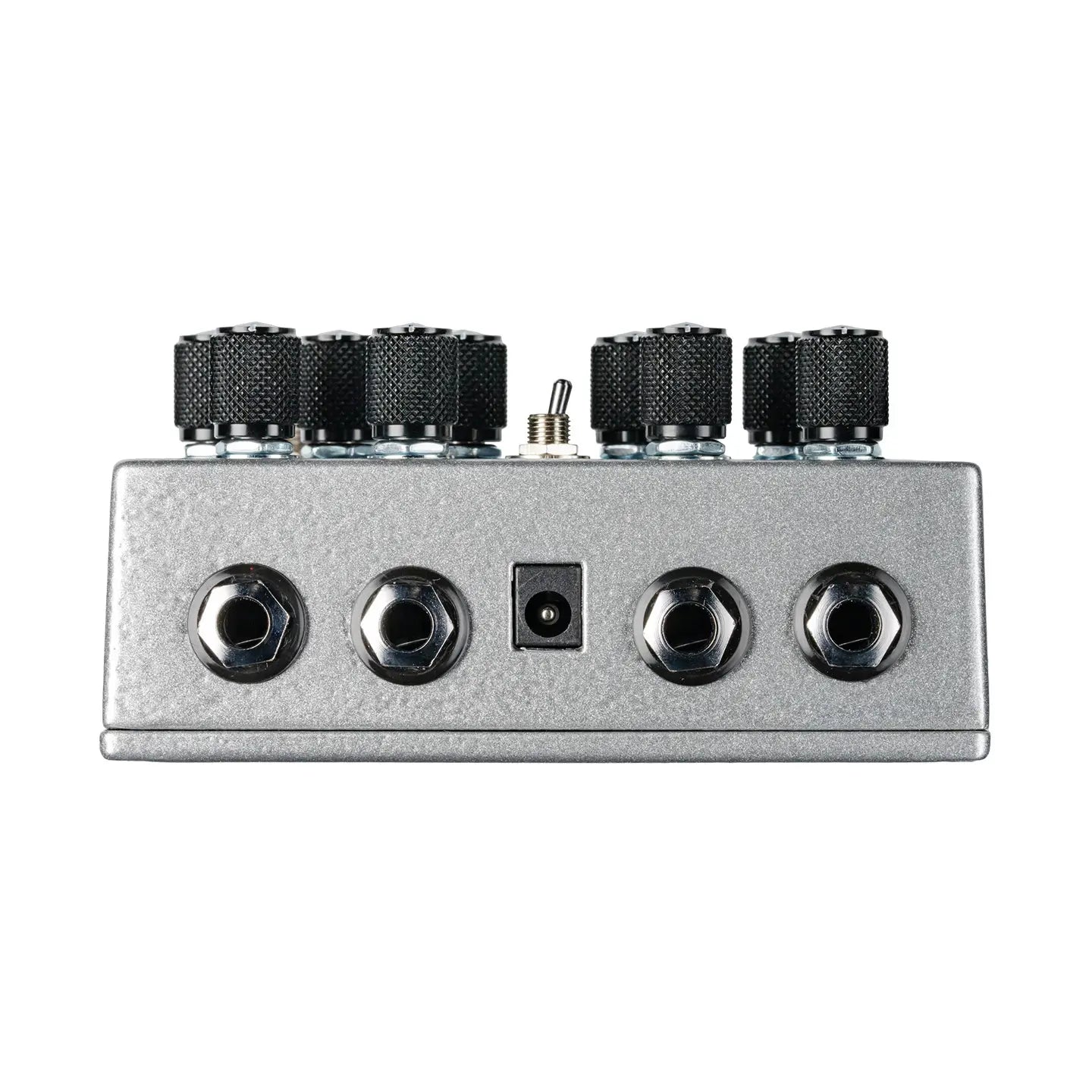 Silver FX pedal with four large black knobs, a toggle switch on top, four quarter-inch jacks, and a power input on the front panel.
