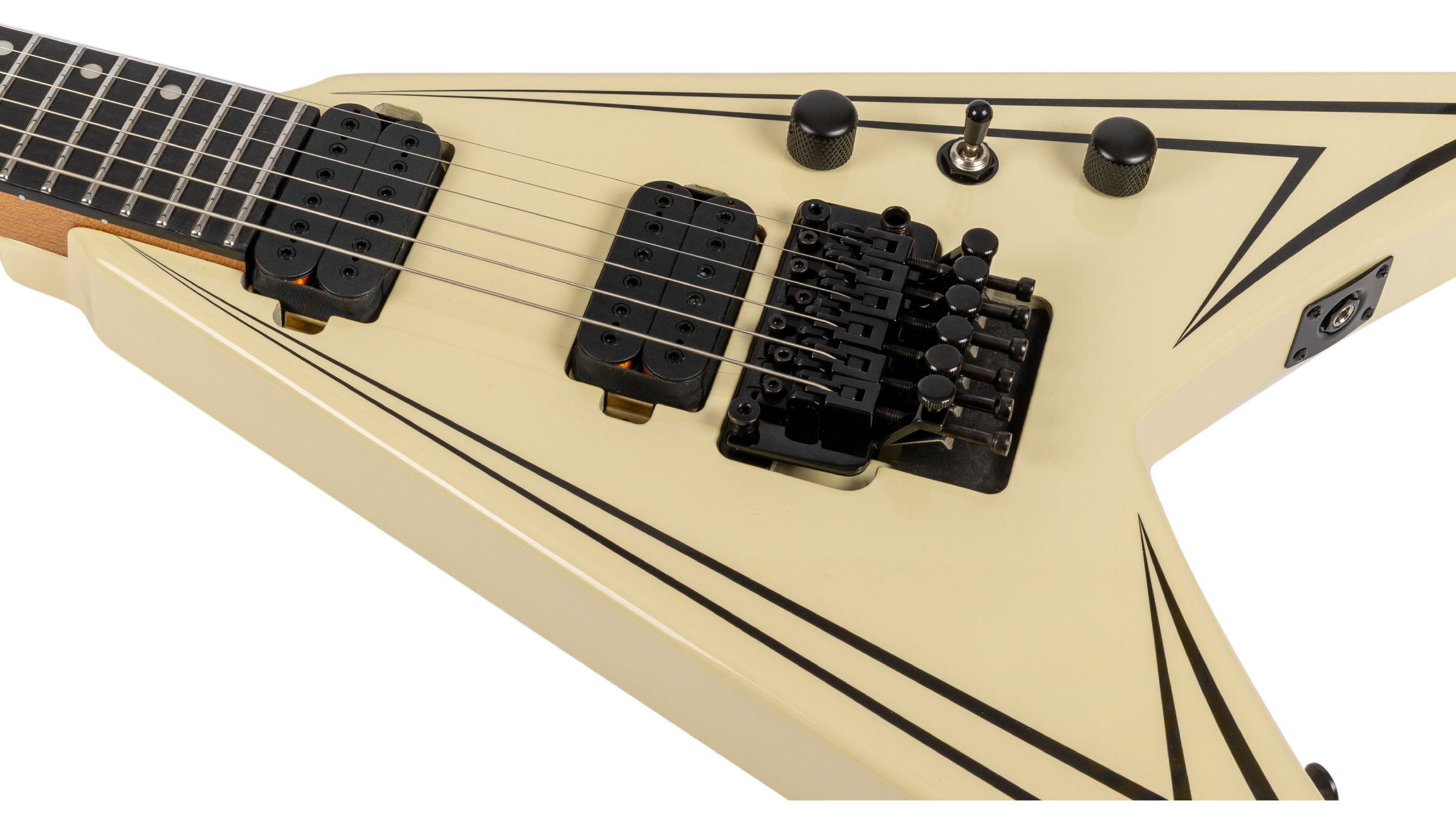 Cream-colored V-shaped electric guitar with black double humbucker pickups, a Floyd Rose tremolo bridge, and sharp black pinstripe accents.