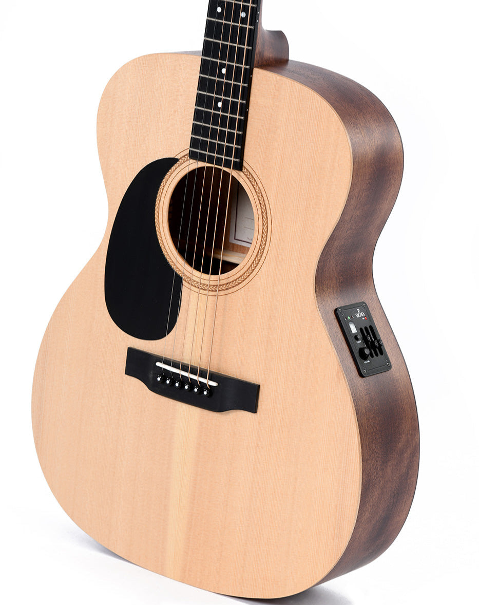 Light wood acoustic guitar with a black pickguard, six strings, soundhole rosette, and electronic controls on the side for amplification.