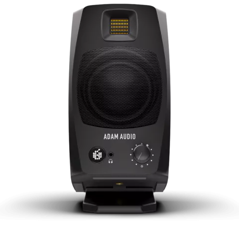Black ADAM Audio studio monitor speaker with visible volume knob, headphone jack, mesh-covered woofer, and a rectangular yellow tweeter.