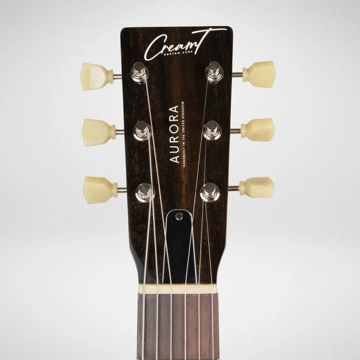 The electric guitar headstock is dark wood with six cream tuning pegs and the words "CreamT," "Aurora," and "Handbuilt in the United Kingdom."