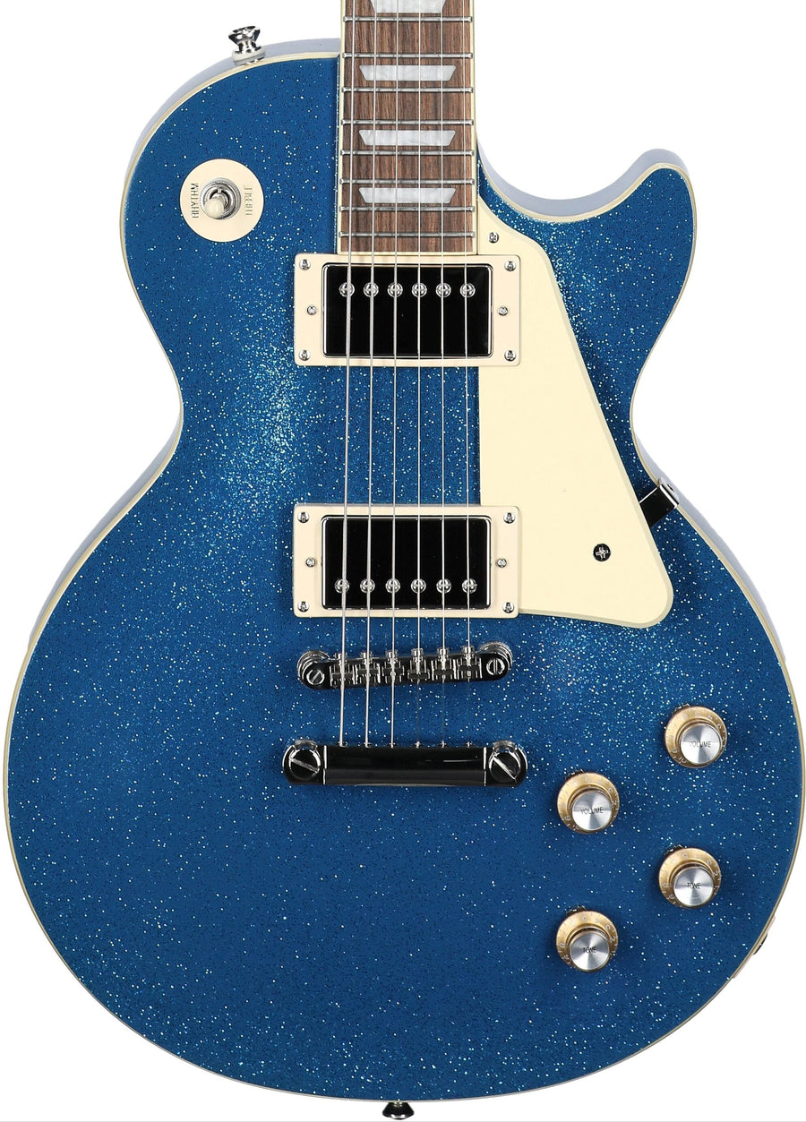 Electric guitar with a single-cutaway shape, blue sparkle finish, cream pickguard, two humbucker pickups, four control knobs, and a toggle switch.