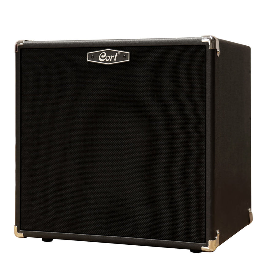 Black Cort amplifier with a square shape, black mesh front, silver corner protectors, and a small silver logo badge at the top center.