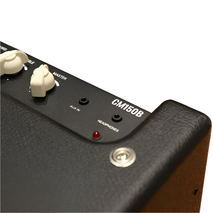 Black amplifier labeled CM150B with white volume and master knobs, auxiliary and headphone jacks, and a small red indicator light.