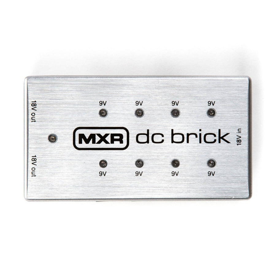Rectangular silver effects pedal power supply labeled "MXR dc brick" with eight 9V outputs and two 18V outputs on a brushed metal surface.