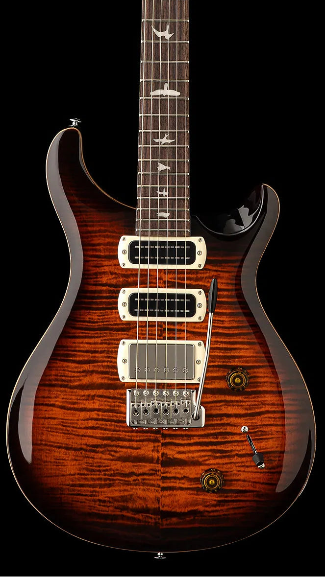 Electric guitar with a glossy tiger-stripe brown finish, three pickups, whammy bar, two knobs, and bird-shaped inlays on the fretboard.