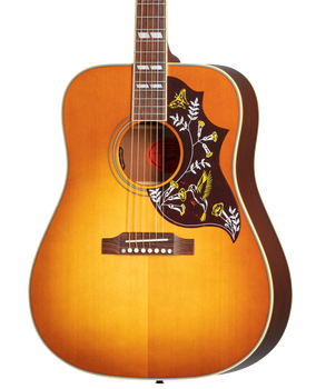 Sunburst acoustic guitar with a large pickguard featuring colorful hummingbird and flower designs.