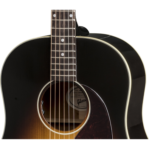 Dark sunburst acoustic guitar with a round sound hole, cream binding, six steel strings, and visible pickguard on the lower right side.