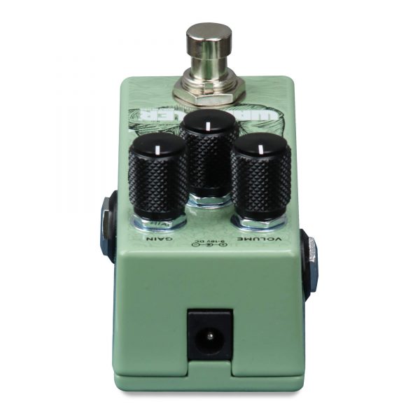 Green effects pedal with three black control knobs labeled gain and volume, a metal footswitch on top, and a power input at the front.