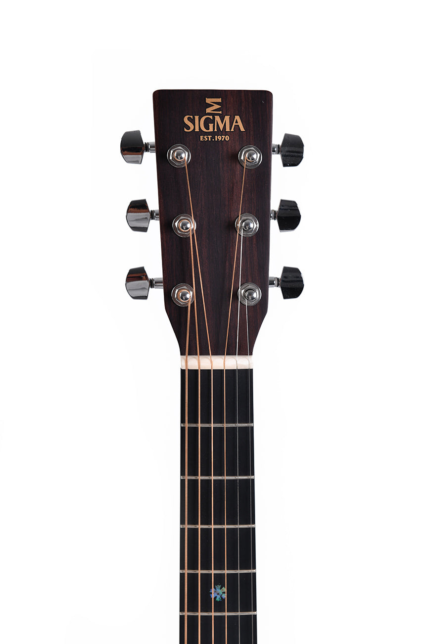 Headstock of a Sigma acoustic guitar with six metal tuning pegs, dark wood finish, and "SIGMA Est. 1970" logo in gold lettering.