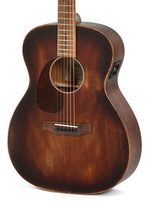 Brown acoustic guitar with a matte finish, rounded body shape, six steel strings, and an electronic input jack on the upper side.