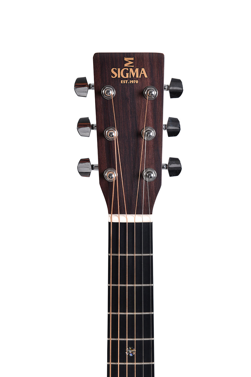 Tête de guitare acoustique en bois foncé, six mécaniques argentées, logo Sigma inscrit en haut, six cordes en métal sur le manche noir.