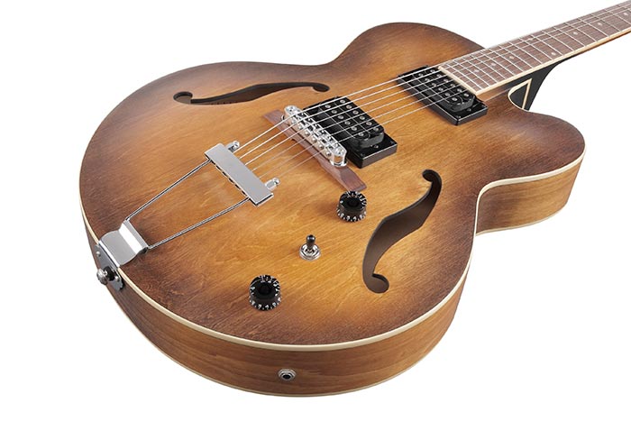 Brown sunburst semi-hollow electric guitar with two black pickups, f-holes, two control knobs, a switch, and a silver tailpiece.