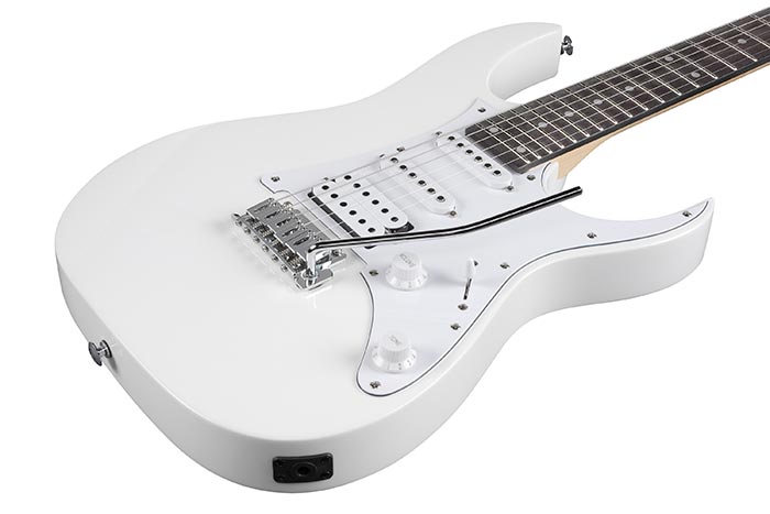 White electric guitar with a double-cutaway body, three pickups, a whammy bar, and two control knobs.