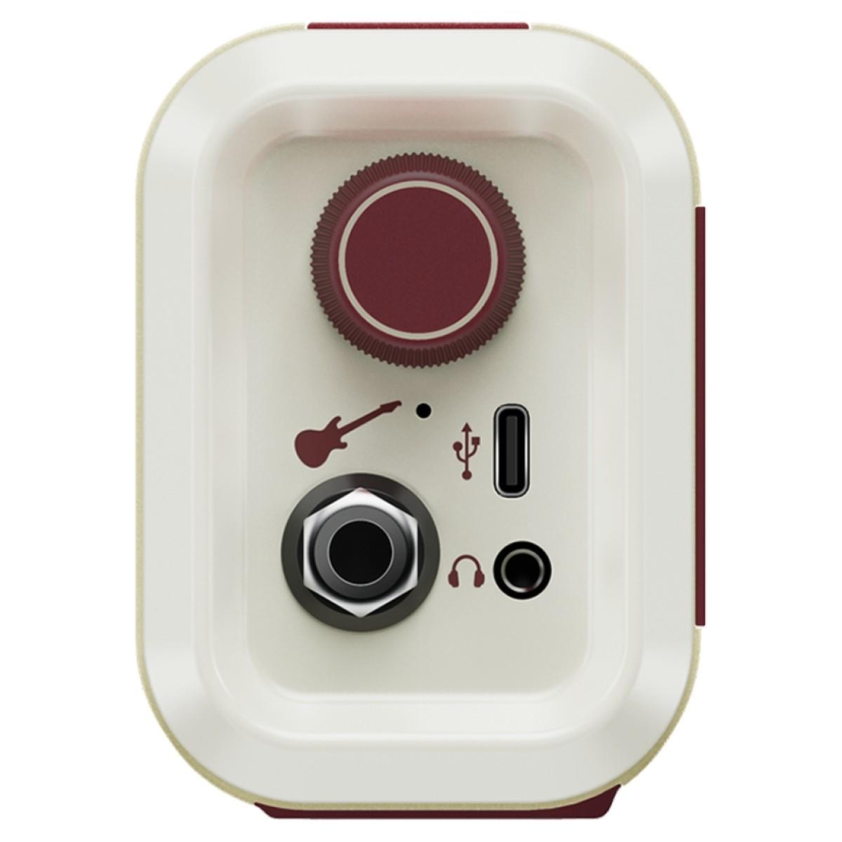 Compact amplifier with a large red control knob, guitar input, USB-C port, and headphone jack on a cream-colored rectangular panel.