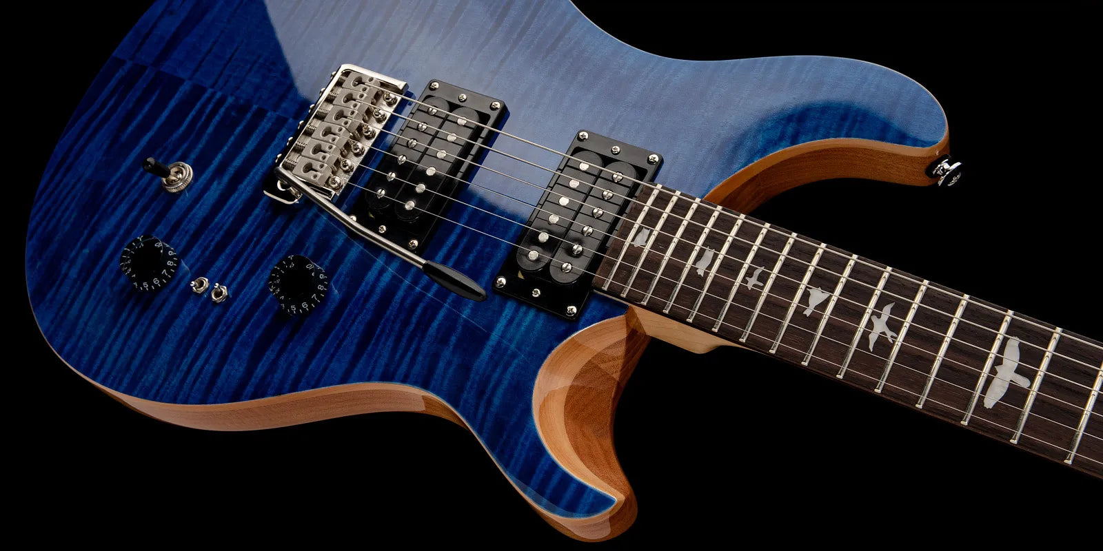 Blue electric guitar with a striped wood grain top, two black humbucker pickups, bird inlays on a dark fretboard, and chrome bridge with tremolo arm.