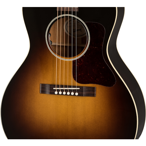Sunburst finish acoustic guitar body with six strings, a dark tortoiseshell pickguard, cream binding, and wooden bridge with white bridge pins.