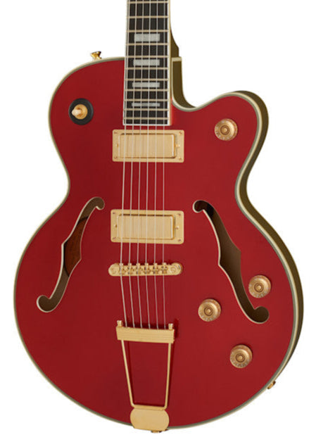 Red electric guitar with gold hardware, two humbucker pickups, four control knobs, and two f-shaped sound holes on a semi-hollow body.