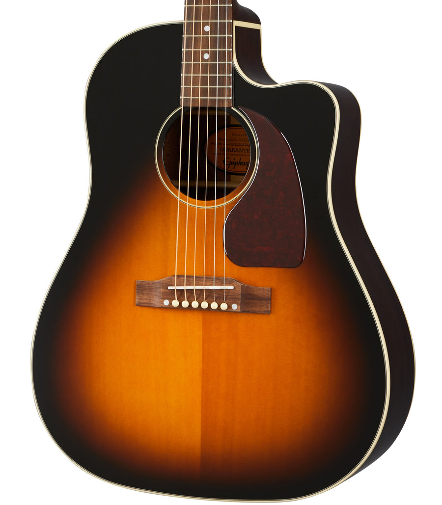 Acoustic guitar with a cutaway body, sunburst finish fading from bright amber in the center to dark brown at the edges, and a dark tortoiseshell pickguard.