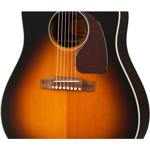 Sunburst acoustic guitar body with six strings, a brown pickguard, and cream binding along the edge. The wood grain is visible near the bridge.