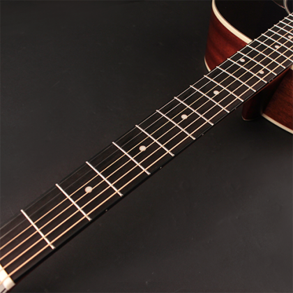 A close-up of an acoustic guitar's neck and fretboard, showing strings, fret markers, and part of the guitar’s dark brown wooden body.