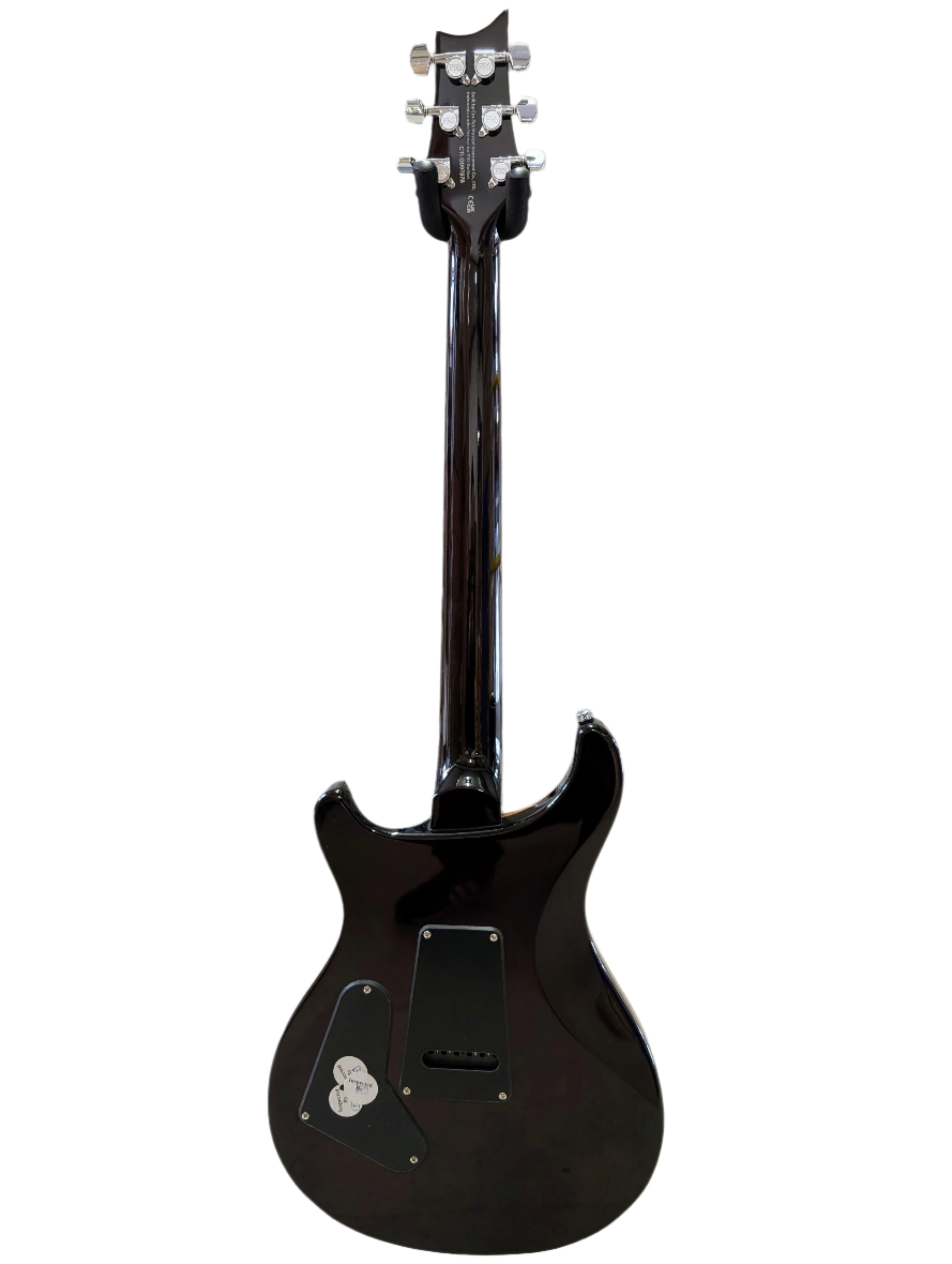 Glossy black electric guitar shown from the back, revealing the neck, six tuning pegs, and control cavity covers on the body.