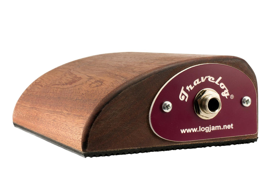 Compact wooden percussion stomp box with a sloped top, rubber base, and a single quarter-inch output jack labeled "Travelog."