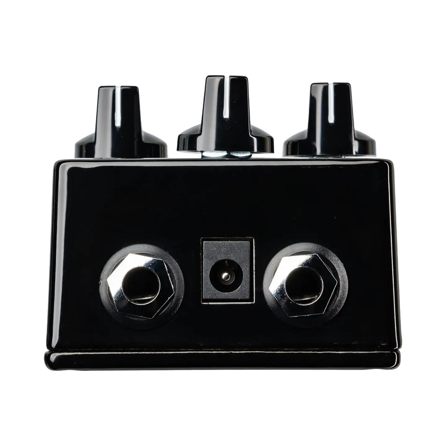 Pédale d'effet noire pour guitare avec trois boutons sur le dessus, deux prises jack et une prise d’alimentation à l’arrière.