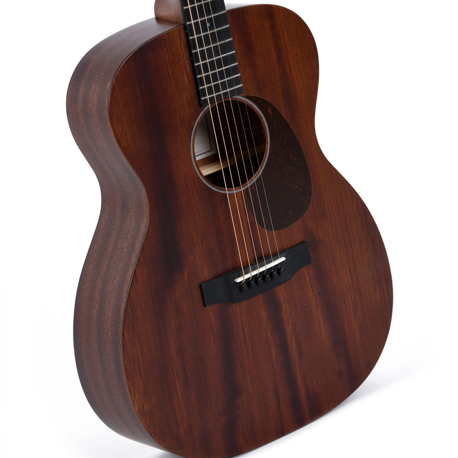 Dark wood acoustic guitar with a matte finish, black pickguard, six steel strings, and a simple bridge design. No ornamentation or cutaway.