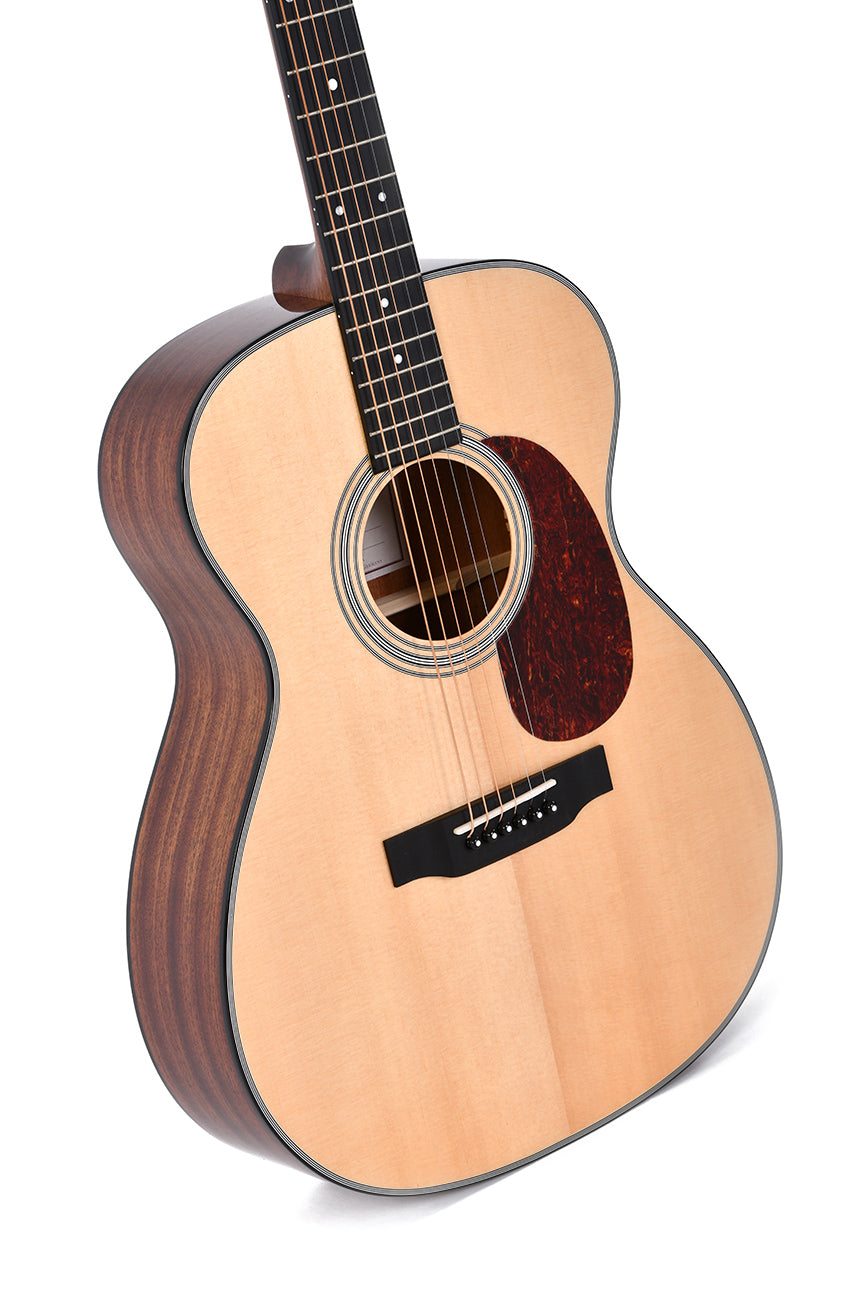 Acoustic guitar with a light wood top, dark wood sides, six strings, dark pickguard, and round sound hole.