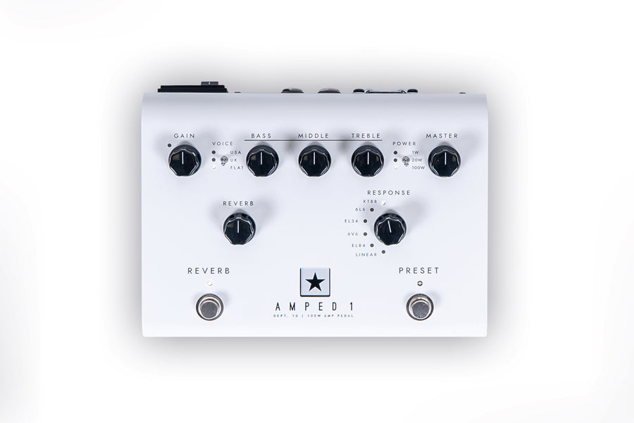 White amplifier pedal with seven black knobs labeled gain, bass, middle, treble, master, reverb, and response, plus two footswitches for reverb and preset.