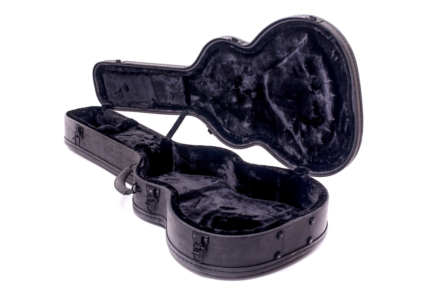 Open black hard-shell acoustic guitar case with a plush, contoured interior and metal latches, empty and hinged open on a white background.